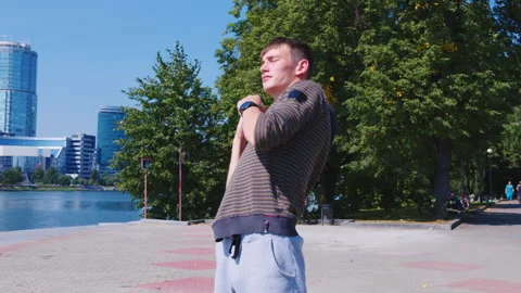A young man is doing warm-up exercises at the city embankment Stock-Footage 146182615