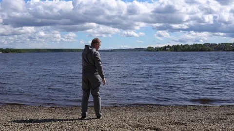 Young man doing warm-up to workout on the shore of a lake . Stock Footage 90942257