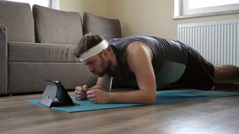 Young man doing yoga exercises on a mat, plank. Sport in quarantine at home Stock Footage 130245160