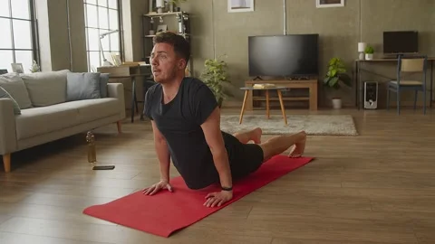 Young man doing yoga at home in living room Stock Footage 169015105