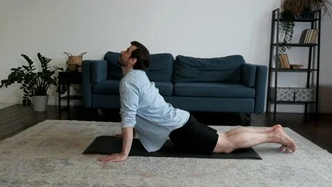 A young Man Is doing Yoga Stretching lying On the Floor of The house in room Stock Footage 144242236