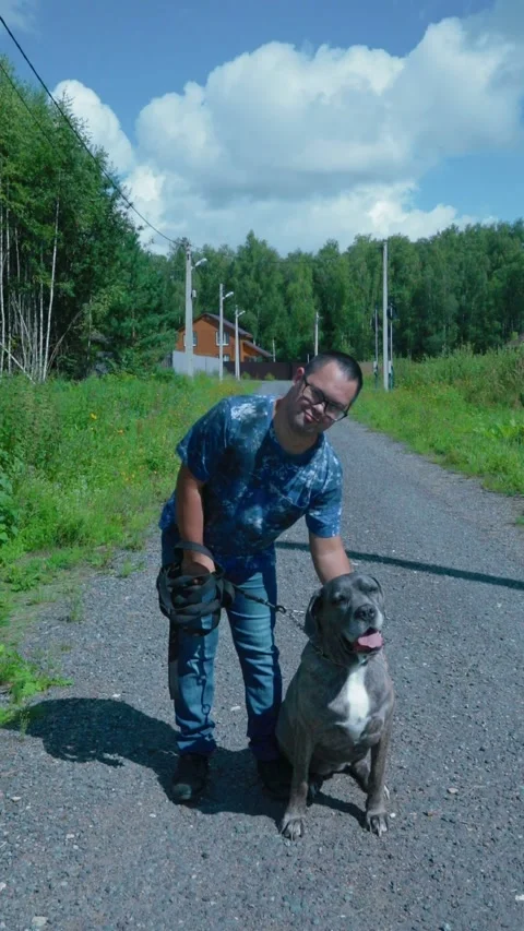A young man with Down syndrome walks with a dog Stock Footage 281339416