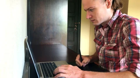 A young man drawing on a graphic tablet at a computer, table Stock Footage 108811129