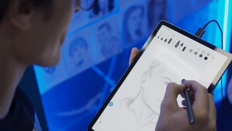 Young man drawing portrait using tablet 動画素材 122520118