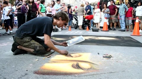 Young man drawing on street sidewalk using chalks Stock Footage 8569071