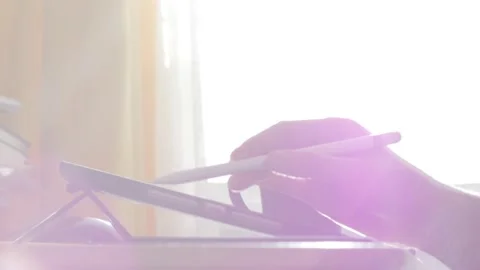 A young man draws with a pen on a tablet pc Stock Footage 220337264