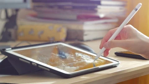 A young man draws with a pen on a tablet pc Stock Footage 220337401