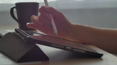 A young man draws with a pen on a tablet pc Stock Footage 220337413