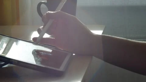 A young man draws with a pen on a tablet pc Stock Footage 220337436