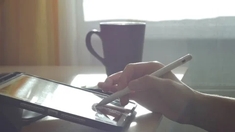 A young man draws with a pen on a tablet pc Stock Footage 220337444