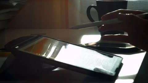 A young man draws with a pen on a tablet pc Stock Footage 220337459
