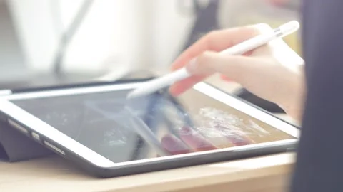 A young man draws with a pen on a tablet pc Stock Footage 220337468