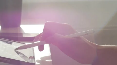 A young man draws with a pen on a tablet pc Stock Footage 220337526