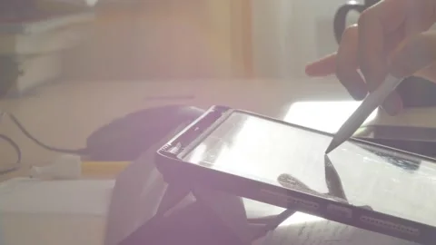 A young man draws with a pen on a tablet pc Stock Footage 220337538