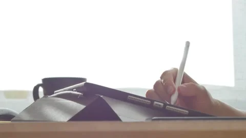 A young man draws with a pen on a tablet pc Stock Footage 220337779