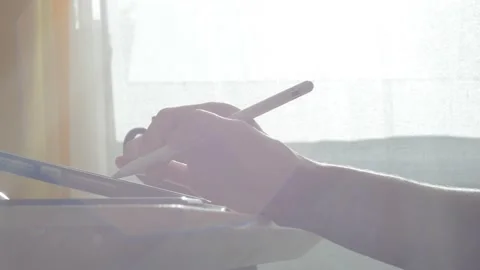 A young man draws with a pen on a tablet pc Stock Footage 220337780