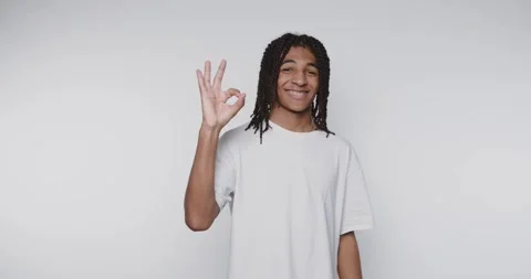 Young man with dreadlocks making an OK gesture, smiling. Stock Footage 315161208