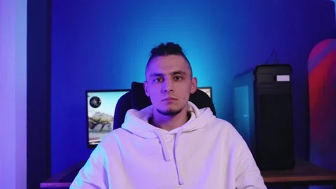 Young man with dreadlocks plays on the computer, takes off headphones Vidéo 143374189