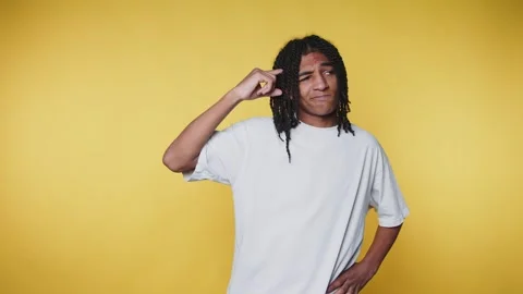 Young man with dreadlocks poses playfully, showcasing expressions of contem.. Stock Footage 313280160