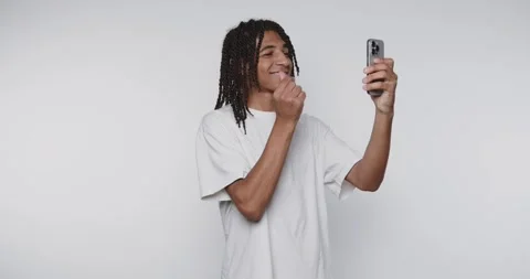 Young man with dreadlocks taking a selfie, smiling and shows a heart gestur.. Stock Footage 315161195