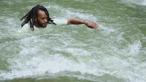 Young Man With Dreadlocks Try To Swimming Against the Current in the River Stock Footage 209128243