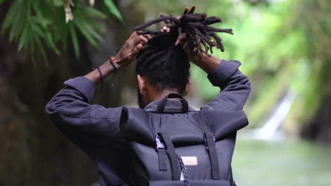 A Young Man With Dreadlocks Try to Tidy His Hair While Giving Charming Smile Stock Footage 207672681