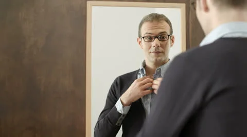Young man dressing up and looking at mirror in fashion shop Stock Footage 23171948