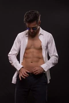 Young man dressing pants unbuttoned shirt Stock-Fotos