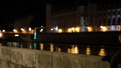 Young man drinking alone in the street next to the river docks in Paris by Stock Footage 92217671