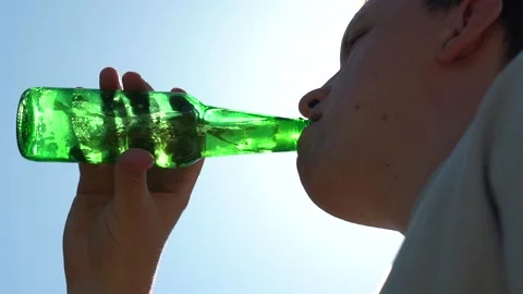 Young Man drinking beer from a bottle Stock Footage 158555994