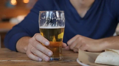 Young man drinking beer in cafe in the city Stock Footage 67861165