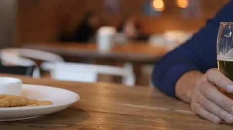 Young man drinking beer in cafe in the city Stock Footage 67861261