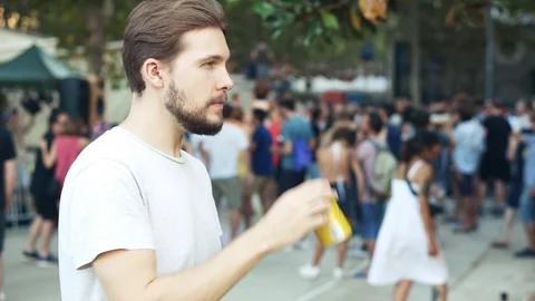 Young man drinking beer from can in park Stock Footage 111779139