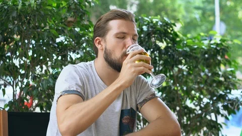 Young man drinking beer outdoors Stock Footage 125655331