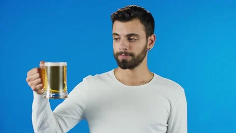 Young man drinking beer, showing beer and smiling at camera. Stock Footage 140538485