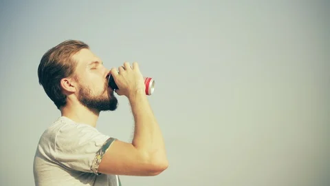 Young Man Drinking Beverage with Sky at Background Stock Footage 129349915