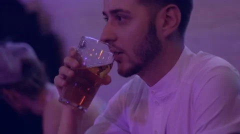 Young man drinking cider in a bar in the evening. Stock Footage 66456772