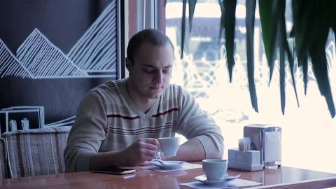 Young man drinking coffee and relaxing in cafe. Stock Footage 70692553
