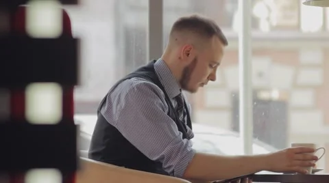 Young man drinking coffee in cafe and using tablet computer Vídeos de archivo 49894501