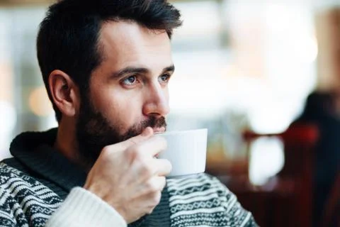 Young man drinking coffee in a cafe Stock Photos
