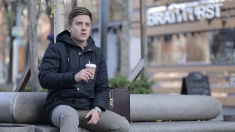 Young man drinking coffee with a disposable paper cup Stock Footage 69880288