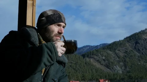 Young man drinking coffee outdoor enjoying the view of the mountains 스톡 동영상 99716990
