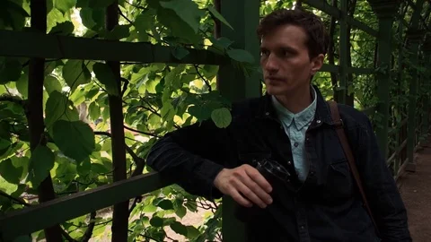 Young man drinking coffee standing at city park. Summer day Video stock 77169030
