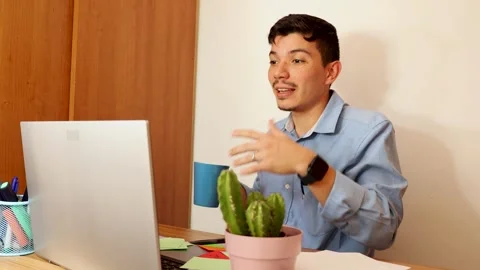 Young man drinking coffee while talking on video call conference on laptop .. Video stock 292875463