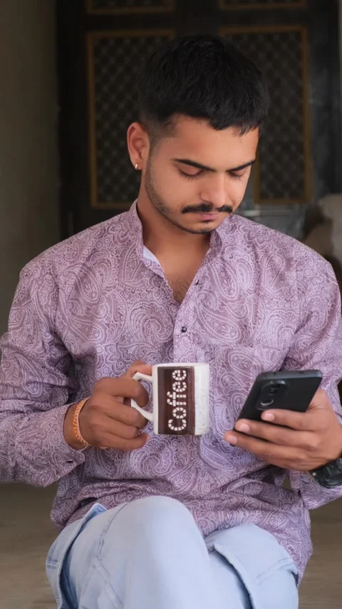 Young Man Drinking Coffee While Using Smartphone – Multitasking Lifestyle Stock Footage 330738249