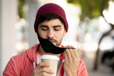 Young man drinking a cup of coffee outdoors. Stock Photos