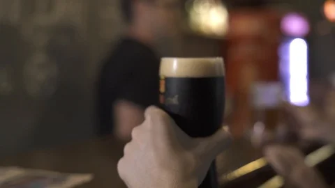 Young man drinking dark beer from glass in pub bar close up. Portrait handsome Stock Footage 104416201