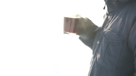 Young man drinking hot coffee outdoors in cold winter day Stock Footage 58774284