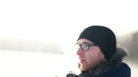 Young man drinking hot coffee outdoors in cold winter day Stock Footage 58774292