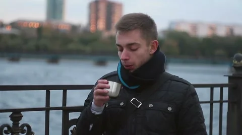 A young man drinking a hot drink from a thermos Stock Footage 69007063